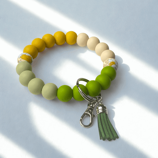 Beaded bracelet with a keychain and tassel on a light background