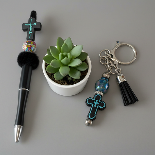 Pen, small plant, and keychain with cross design on a white background