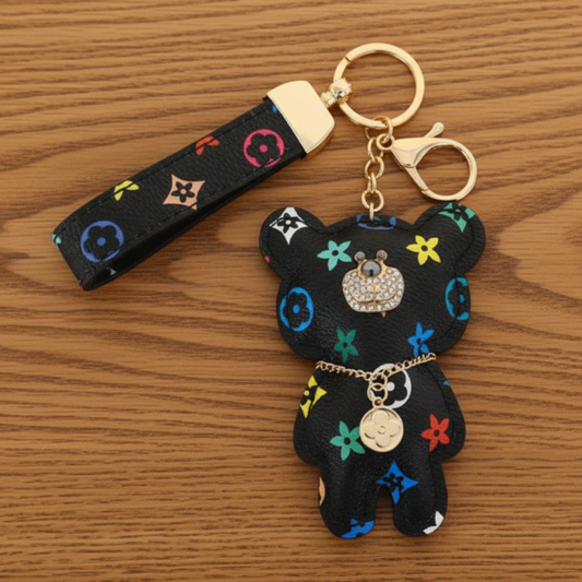 Black bear-shaped keychain with colorful designs on a white background