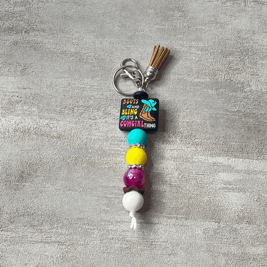 Colorful beaded keychain with a clip on a textured gray background