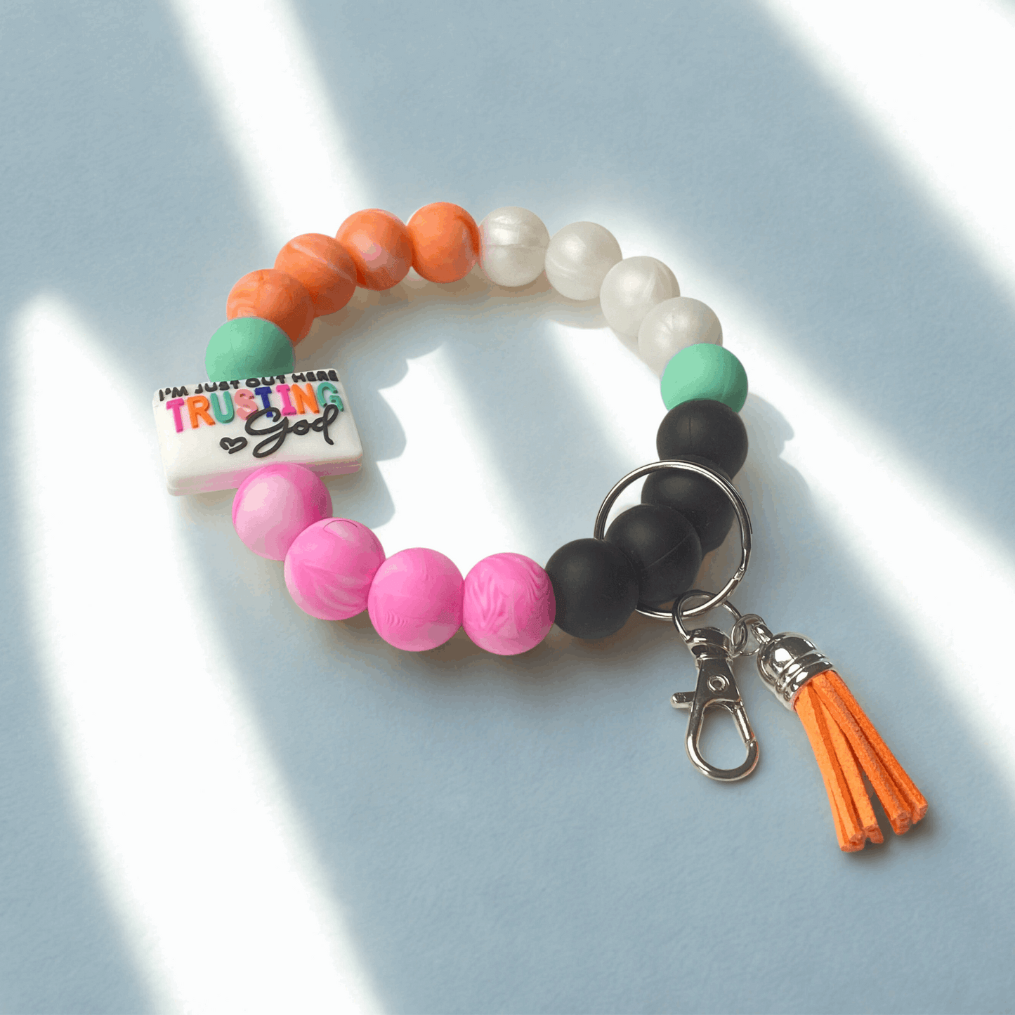 Beaded keychain with a smiley face charm on a white background