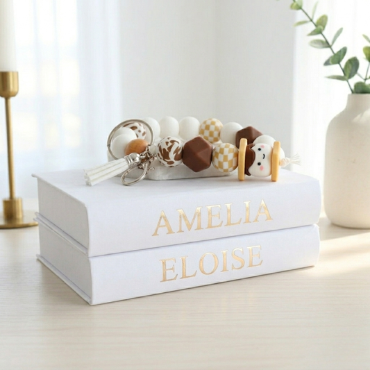 White box with 'Amelia Eloise' branding, containing baby toys on a light wooden surface.