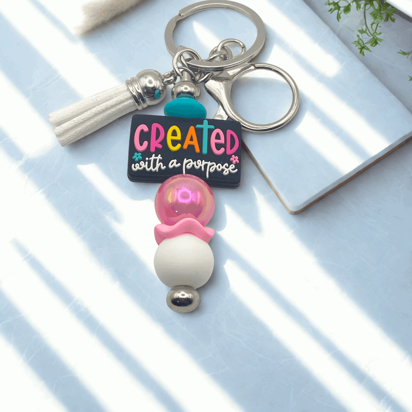 Keychain with 'Created with a Purpose' charm on a light surface