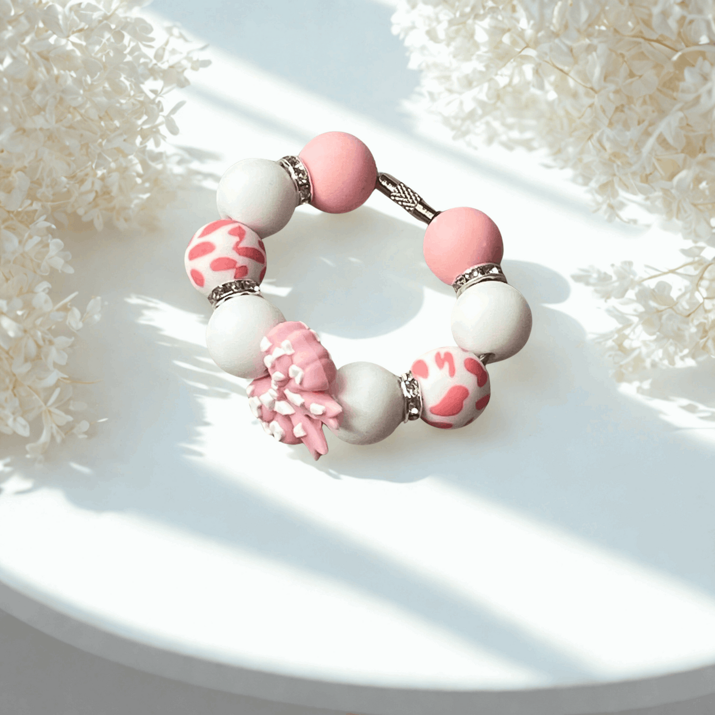 Bracelet with pink and white beads on a textured white surface