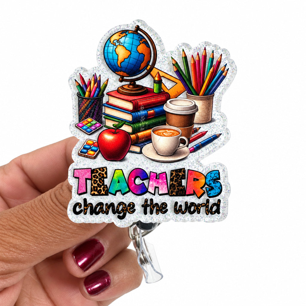 A hand with metallic pink nails holds a die-cut sticker featuring school supplies and the text 'TEACHERS change the world' on a plain white background.