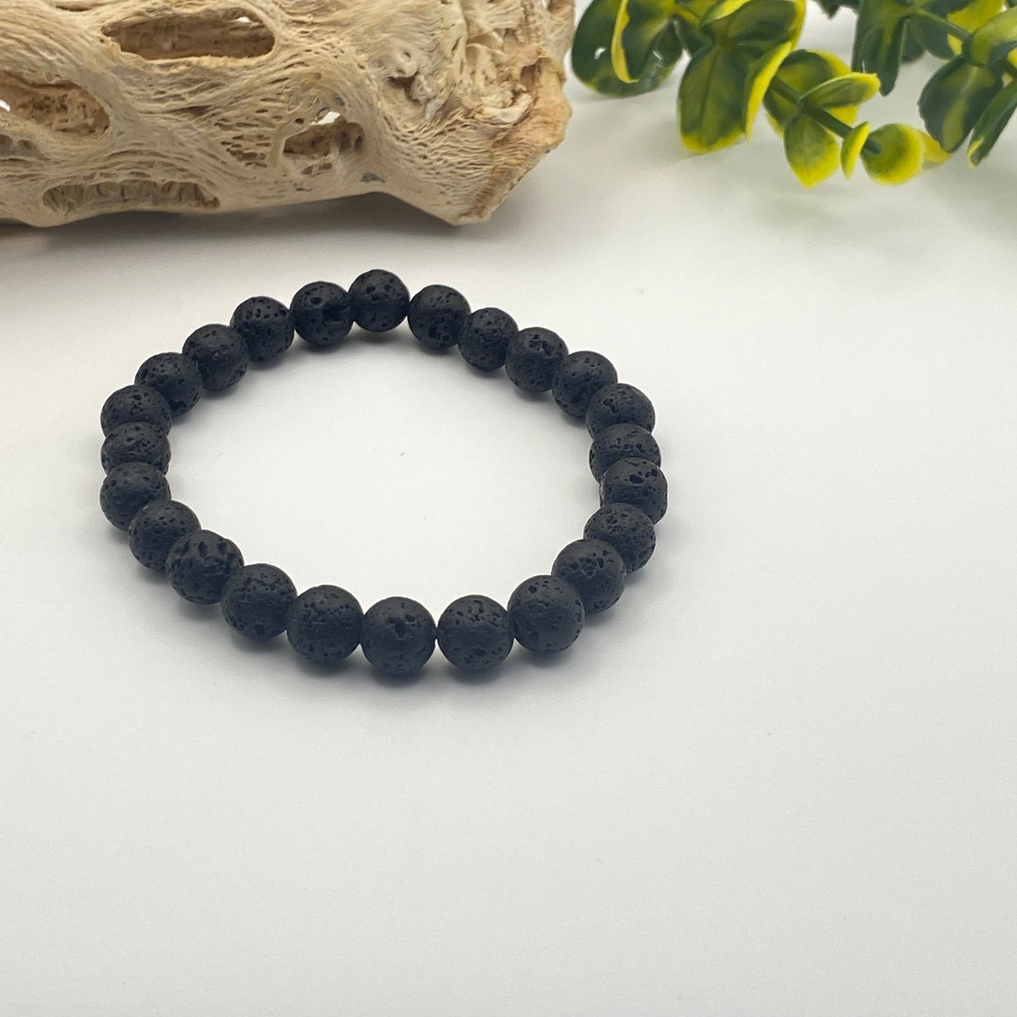 Black beaded bracelet on a white surface with decorative elements