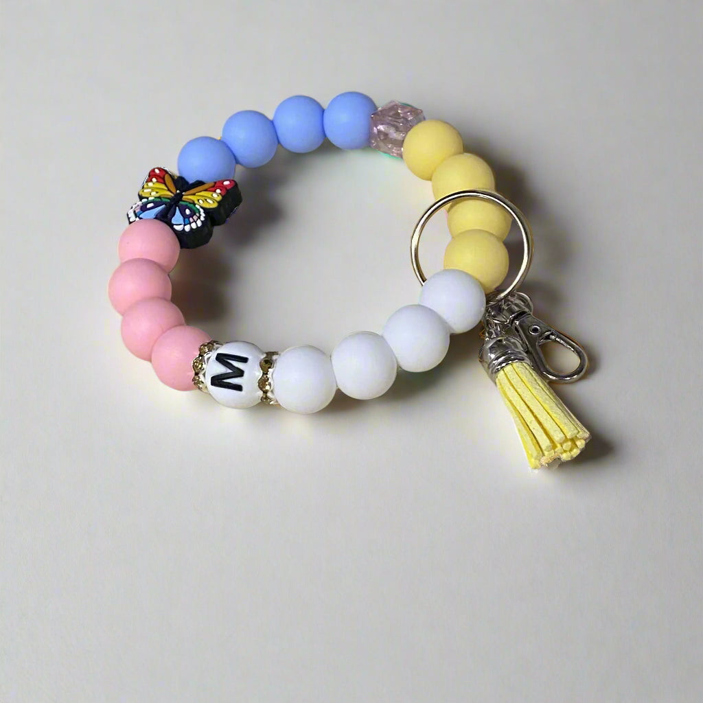 Colorful beaded keychain with a tassel on a beige background