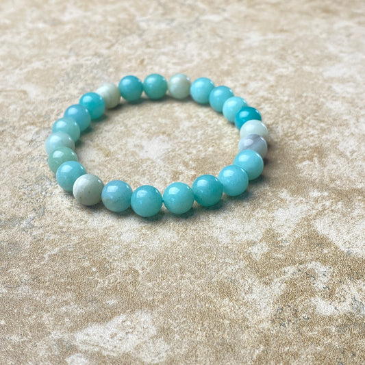 Beaded bracelet with blue and white beads on a textured beige surface