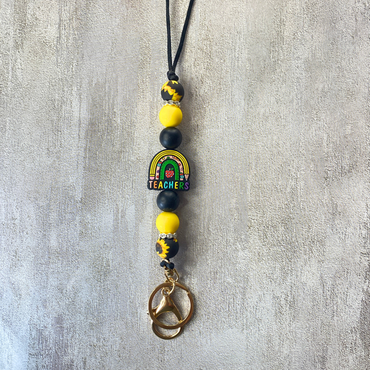 Beaded keychain with rainbow and 'Teacher' charm on a gray background
