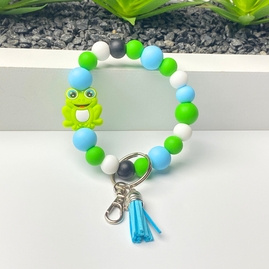 Colorful beaded bracelet with a frog charm on a white background