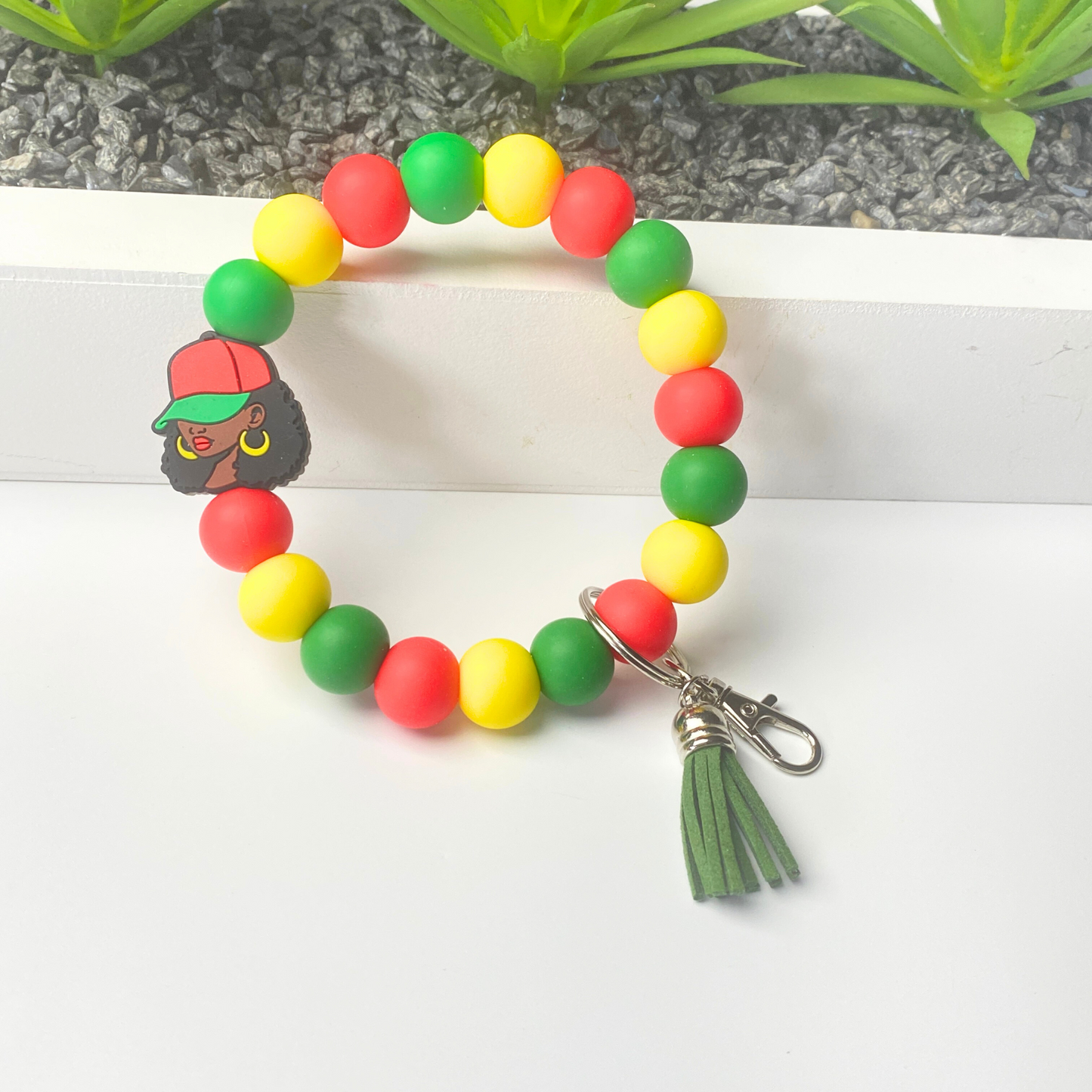 Colorful beaded bracelet with a keychain and tassel on a white background