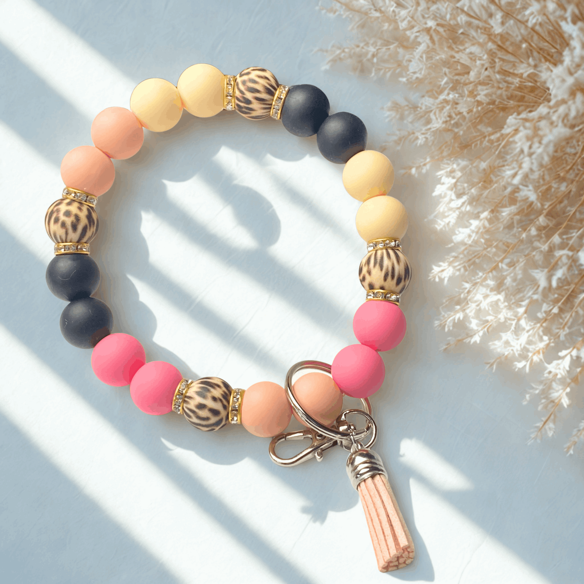 Colorful beaded bracelet with keychain on a light background
