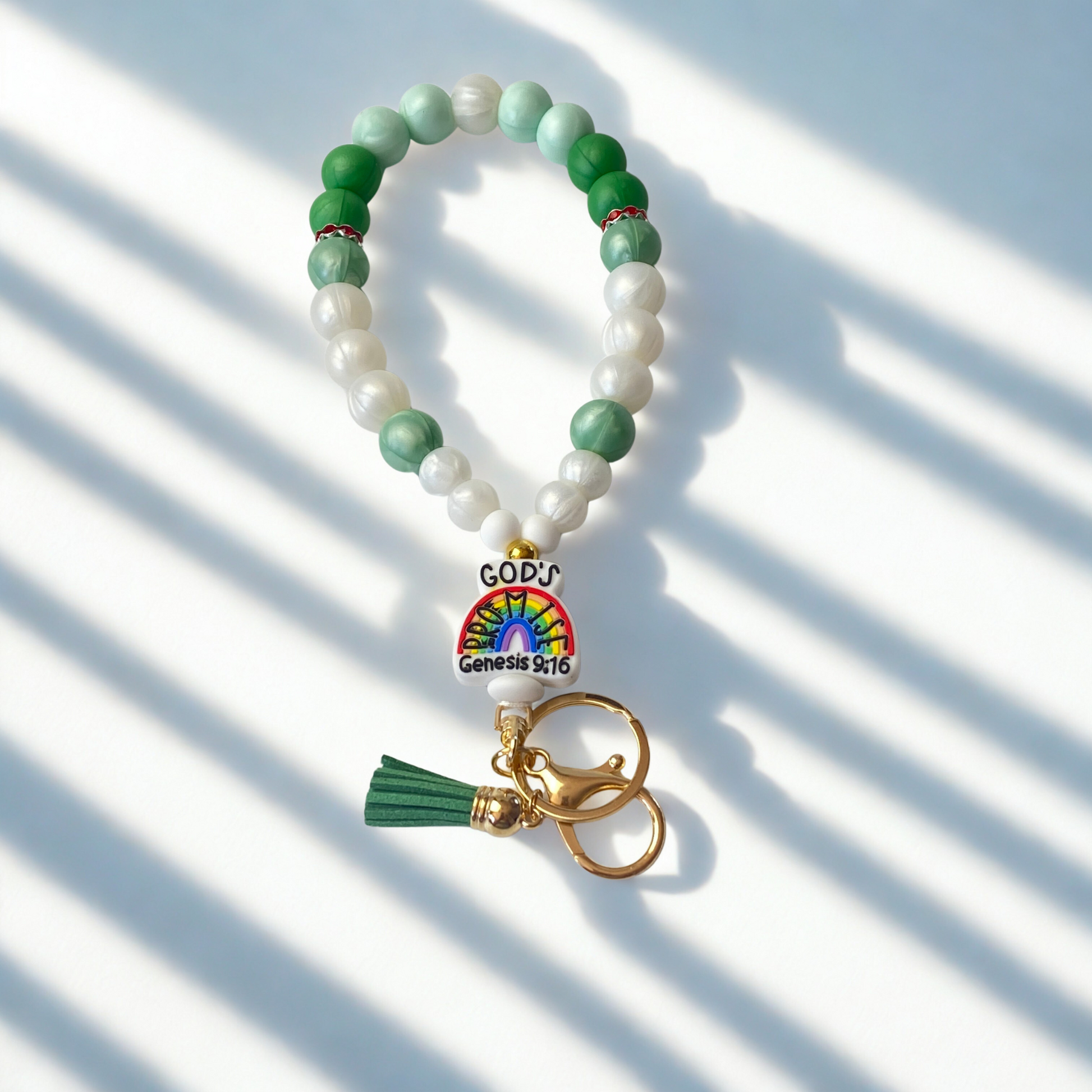 Beaded keychain with rainbow charm and tassel on a light background