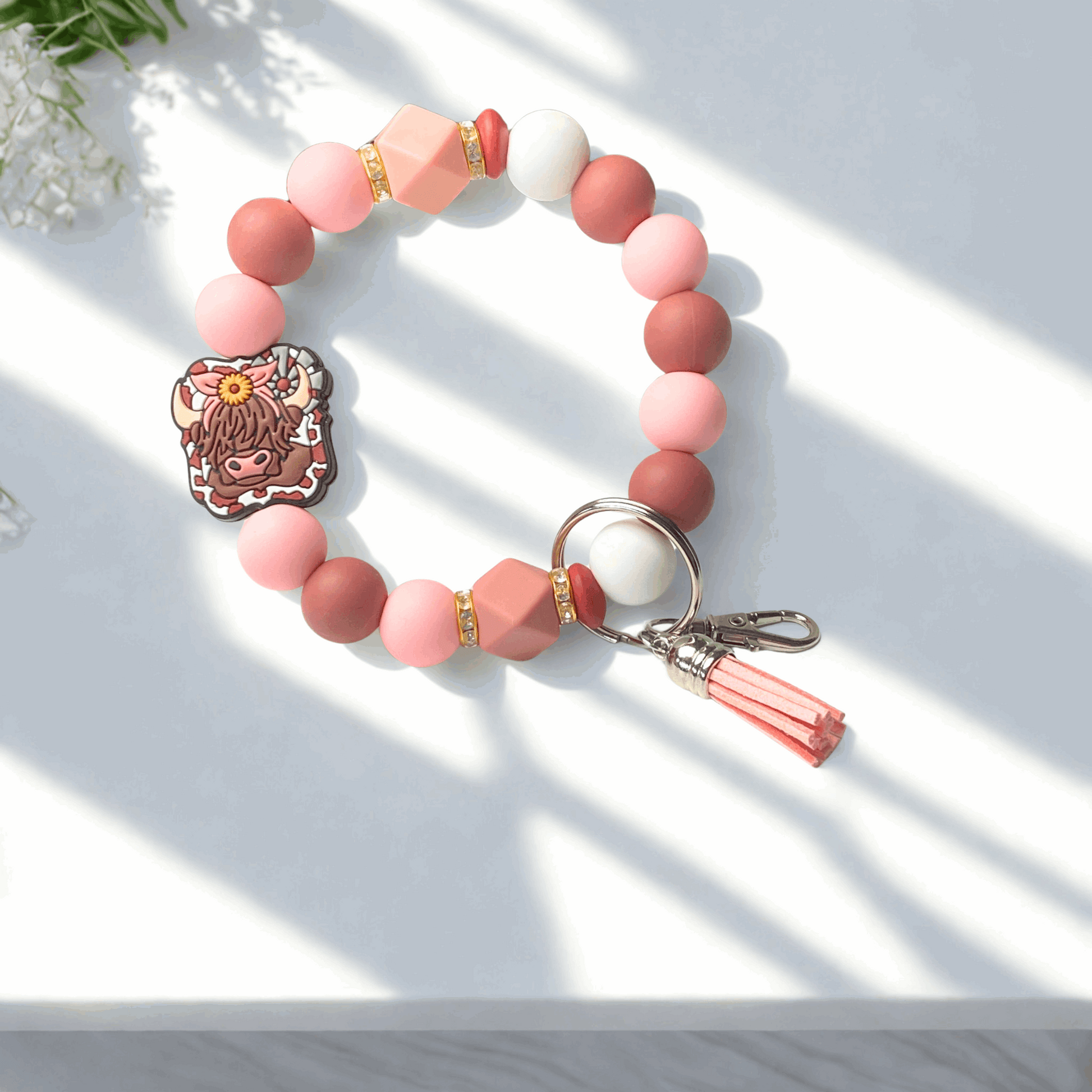 Beaded keychain with a character charm on a light surface