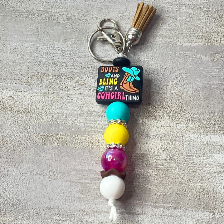 Colorful beaded keychain with a decorative tag on a gray background