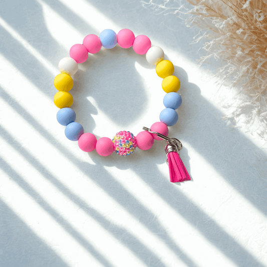 Colorful beaded bracelet with a tassel on a light background