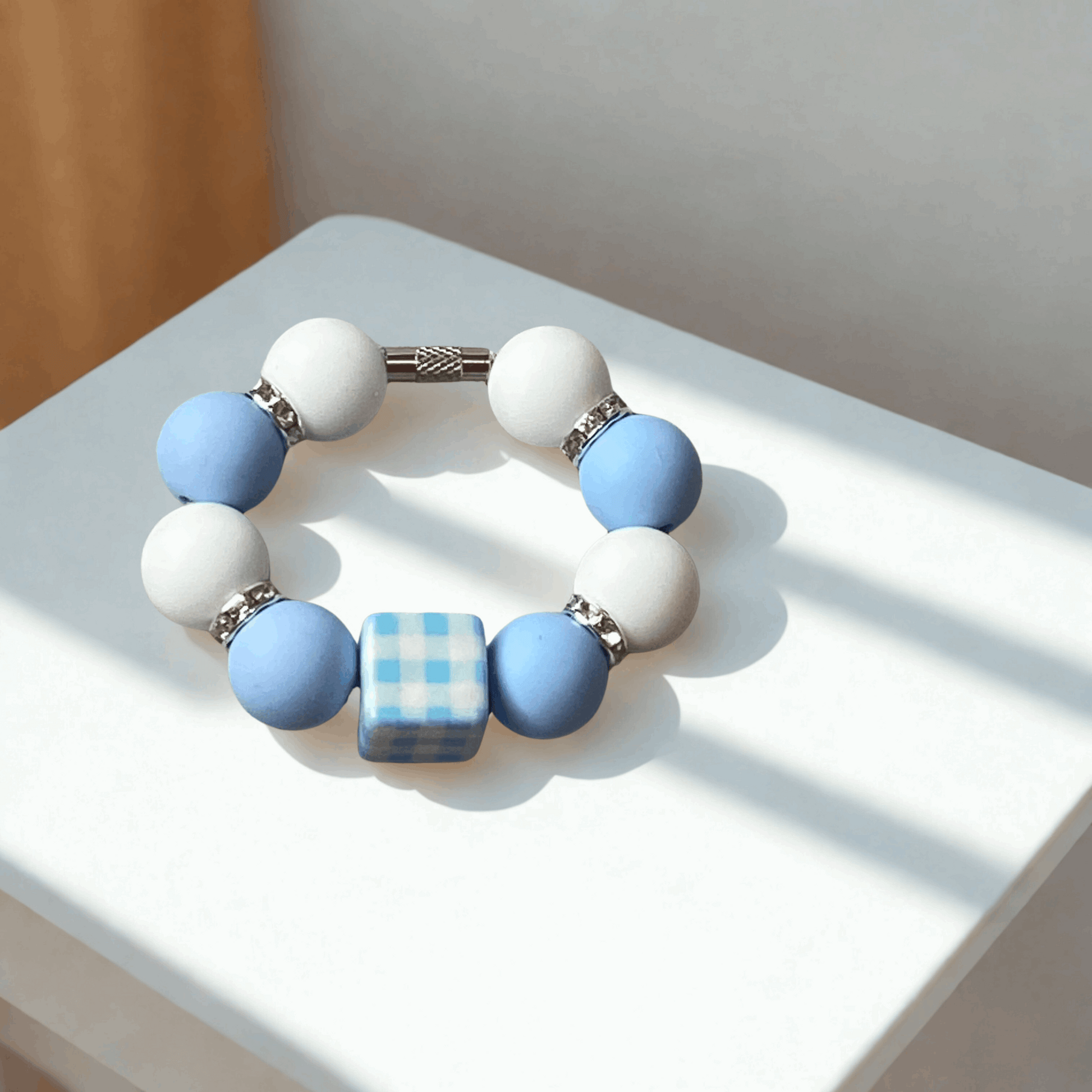 Bracelet with blue and white beads on a light surface
