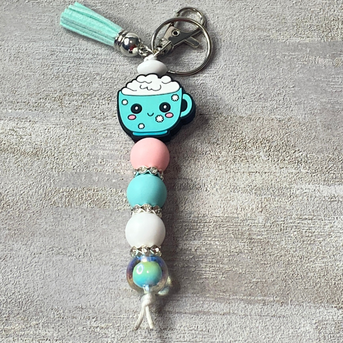 Keychain with a blue cup charm and colorful beads on a gray background