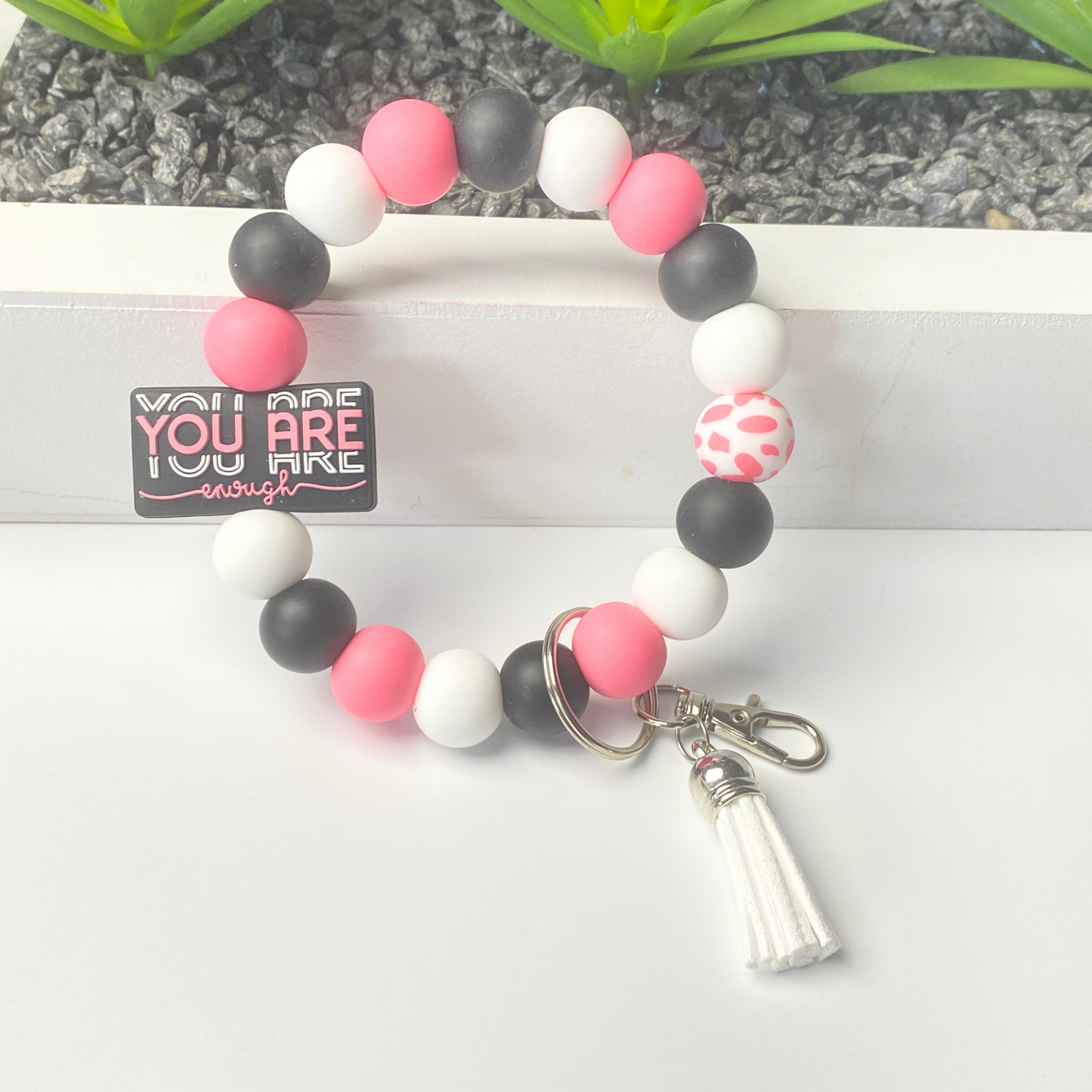 Colorful beaded keychain with a tassel on a white surface