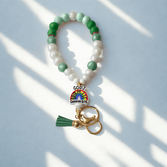 Beaded keychain with rainbow charm and tassel on a light background