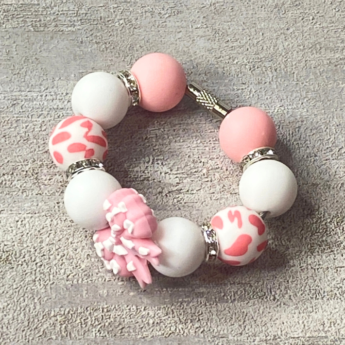 Bracelet with pink and white beads on a textured gray background