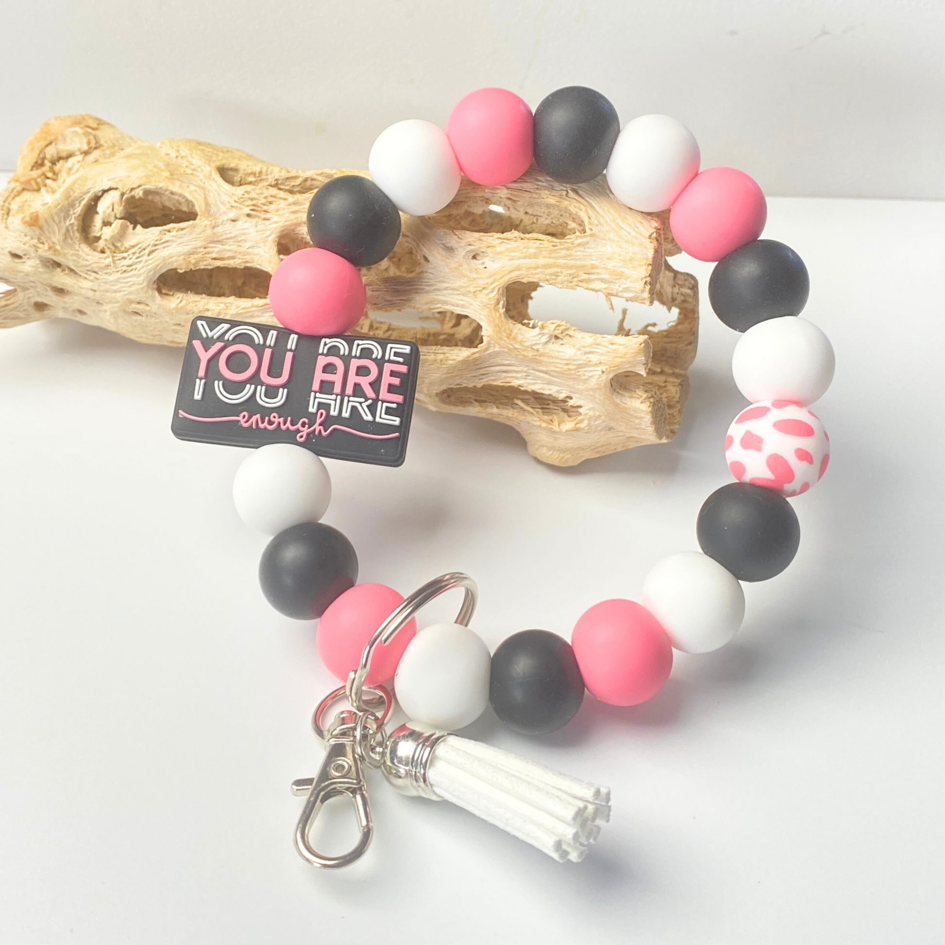 Beaded bracelet with pink, black, and white beads on a white background