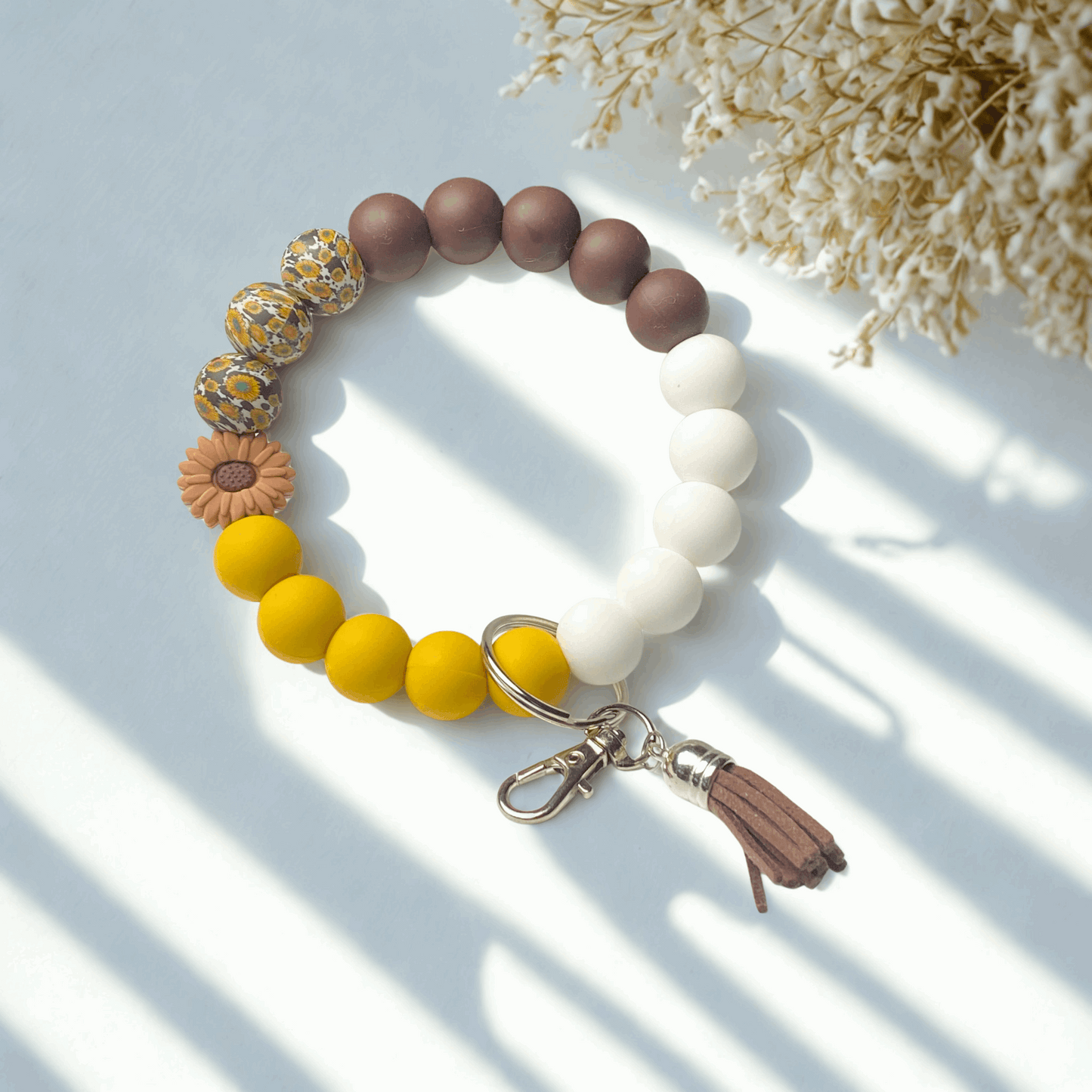 Colorful beaded bracelet with a keychain on a light surface