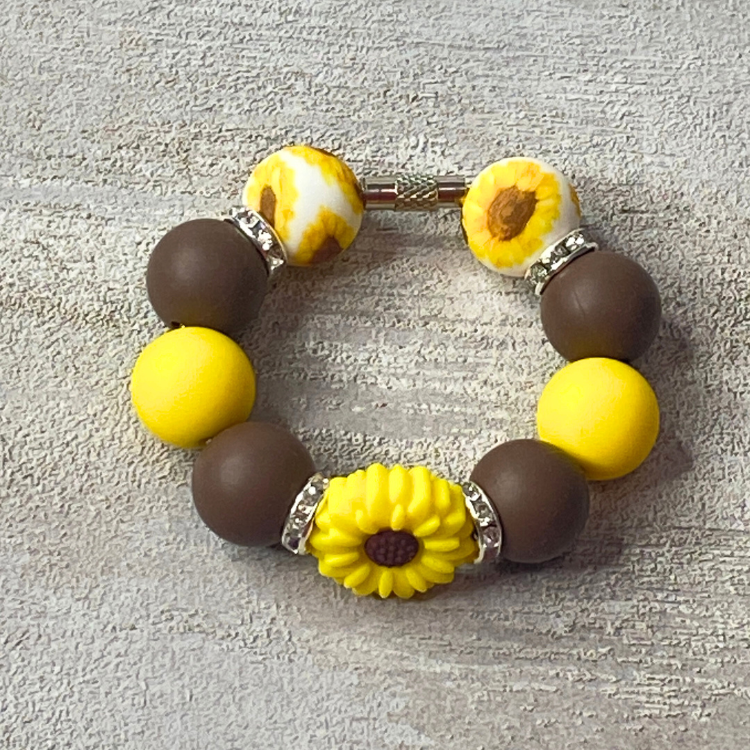 Bracelet with yellow and brown beads on a textured surface