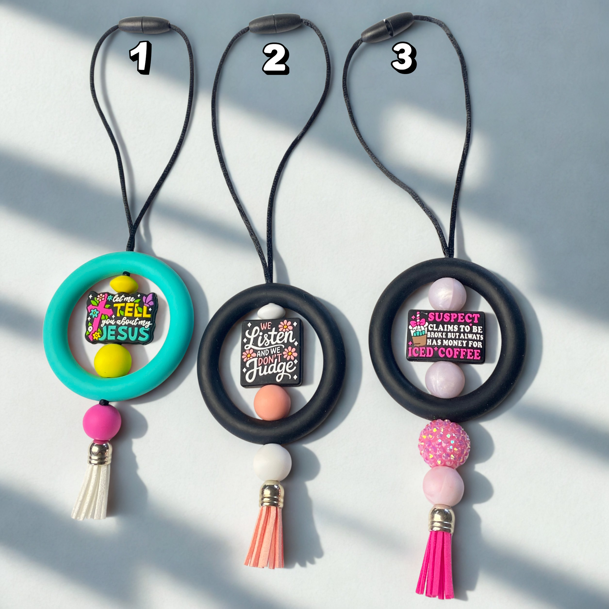 Three decorative keychains with text and colorful beads on a light gray background
