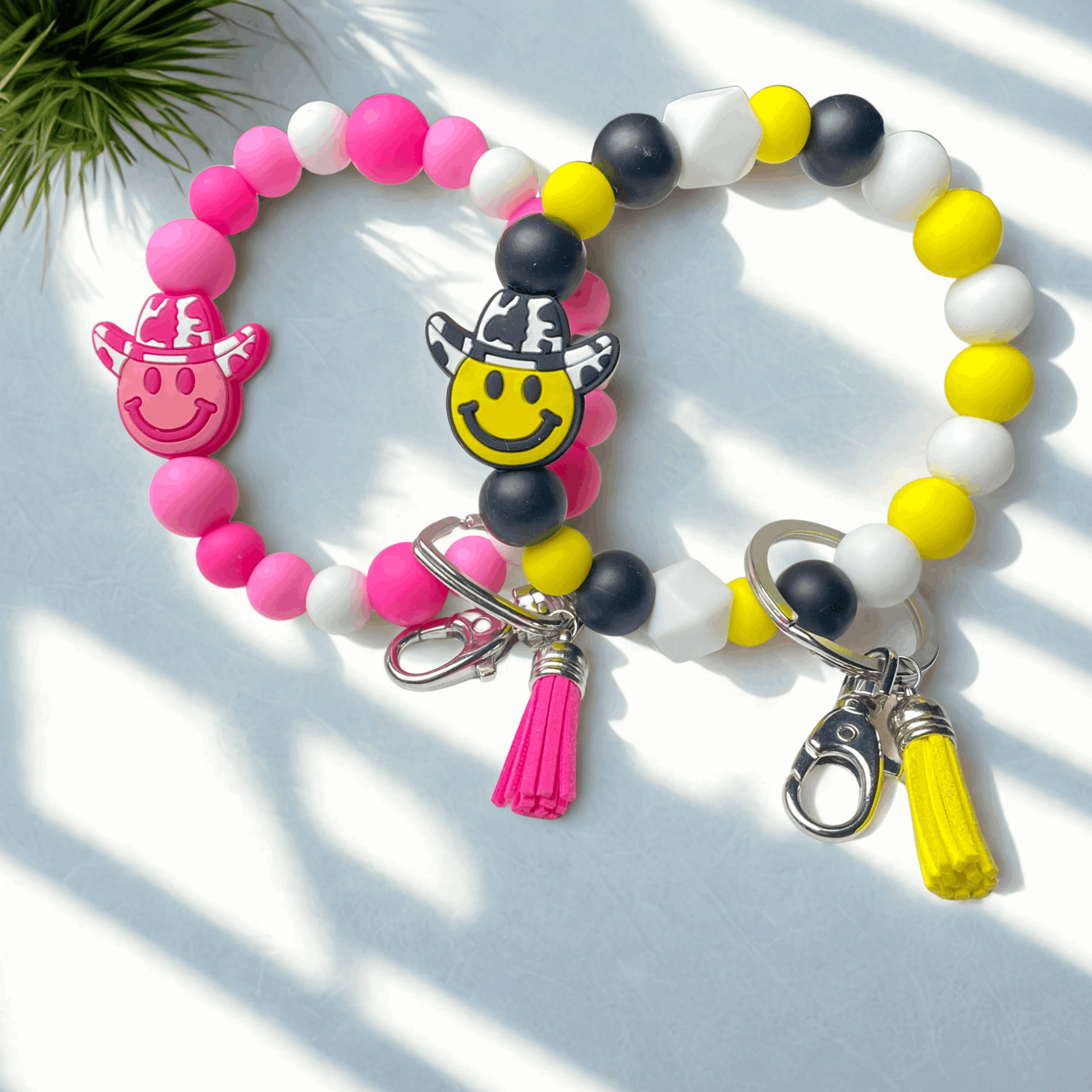 Colorful beaded bracelet with smiley face charms and keychain on a light background