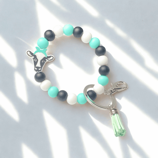 Bracelet with colorful beads and cow charm on a white background