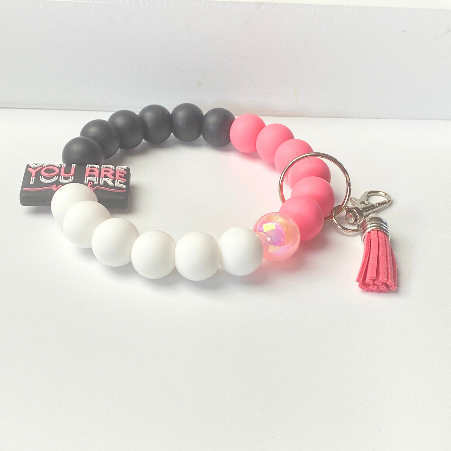 Beaded bracelet with pink, white, and gray beads on a white background