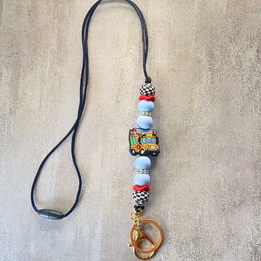 Phone lanyard with colorful beads and a keychain on a textured beige background