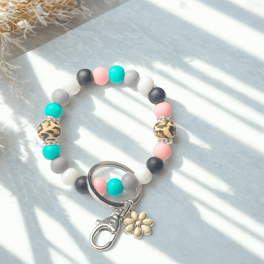 Colorful beaded keychain with leopard print and flower charm on a light surface