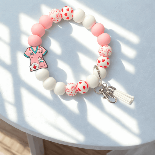 Beaded bracelet with a pink medical-themed charm on a light surface