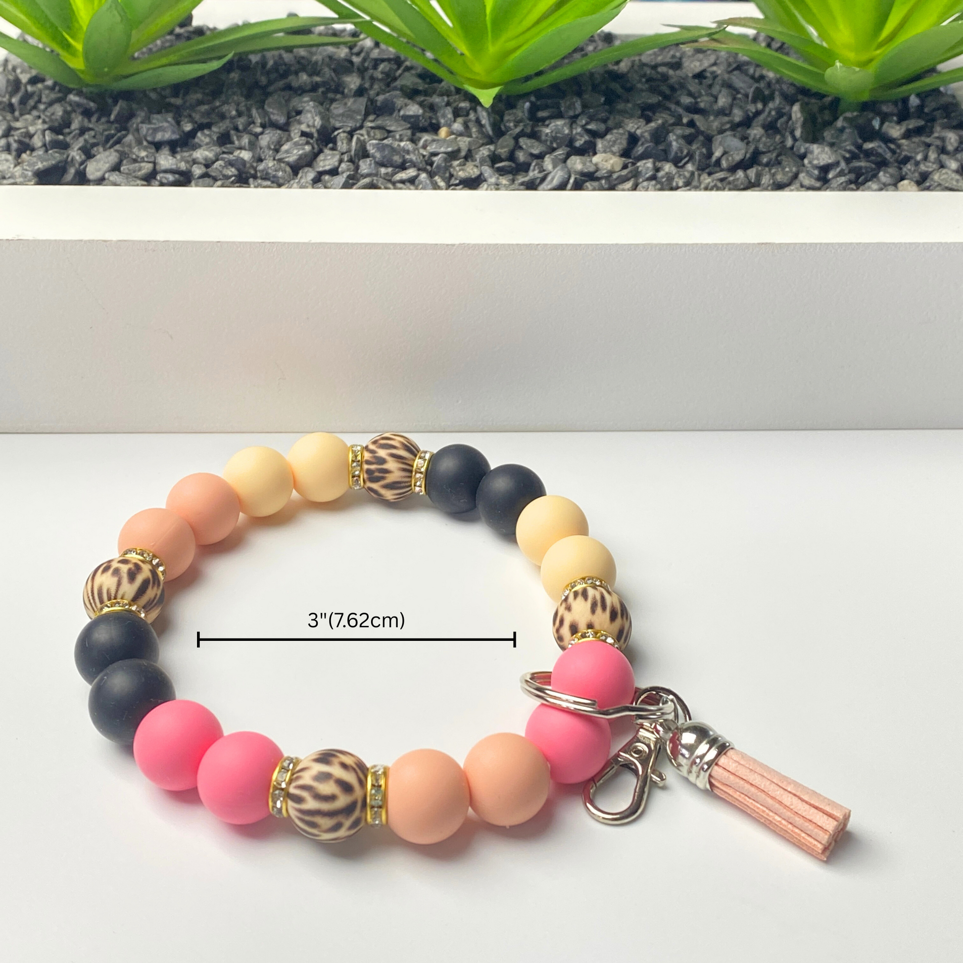 Colorful beaded bracelet with tassel charm on a white background