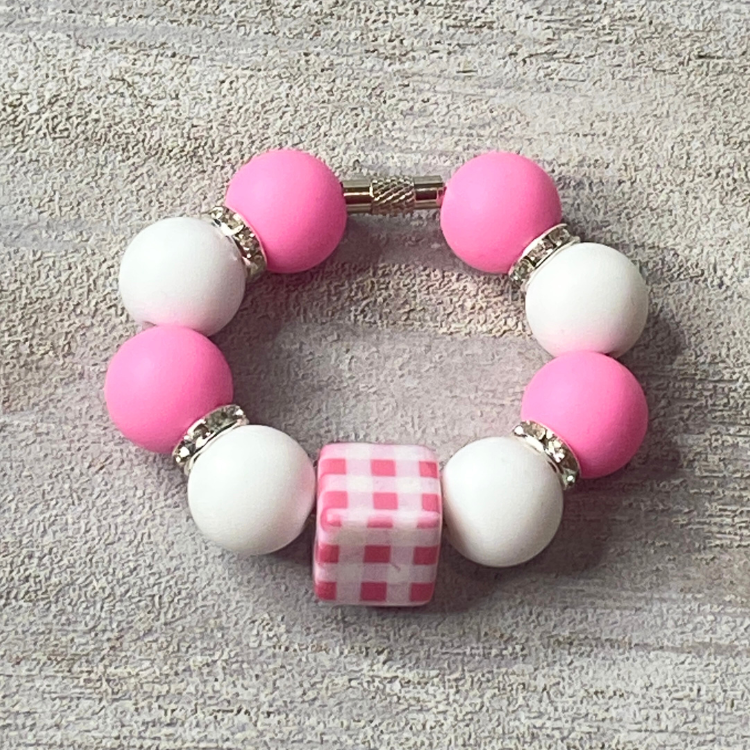 Bracelet with pink and white beads on a textured surface