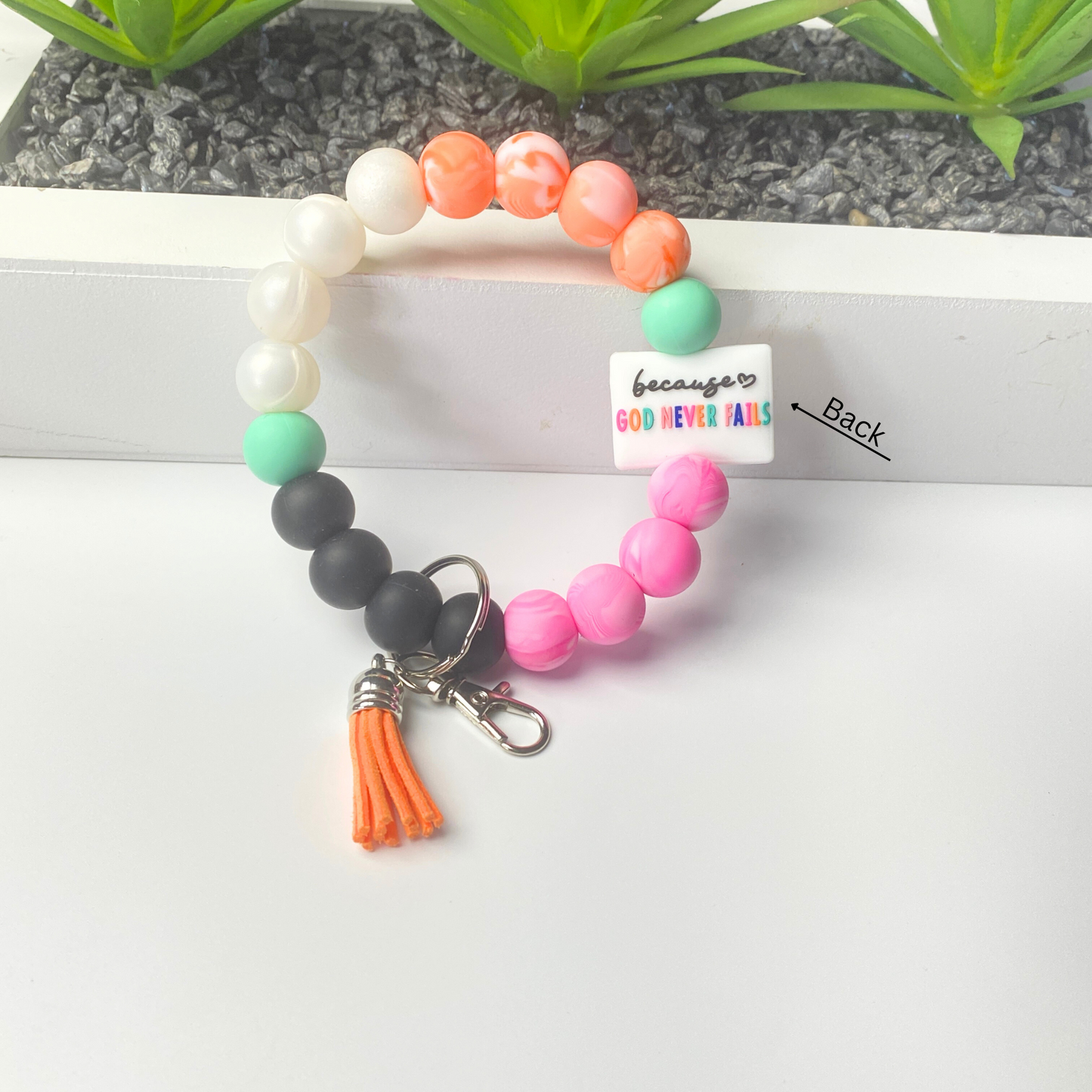Colorful beaded keychain with tassel on a white background