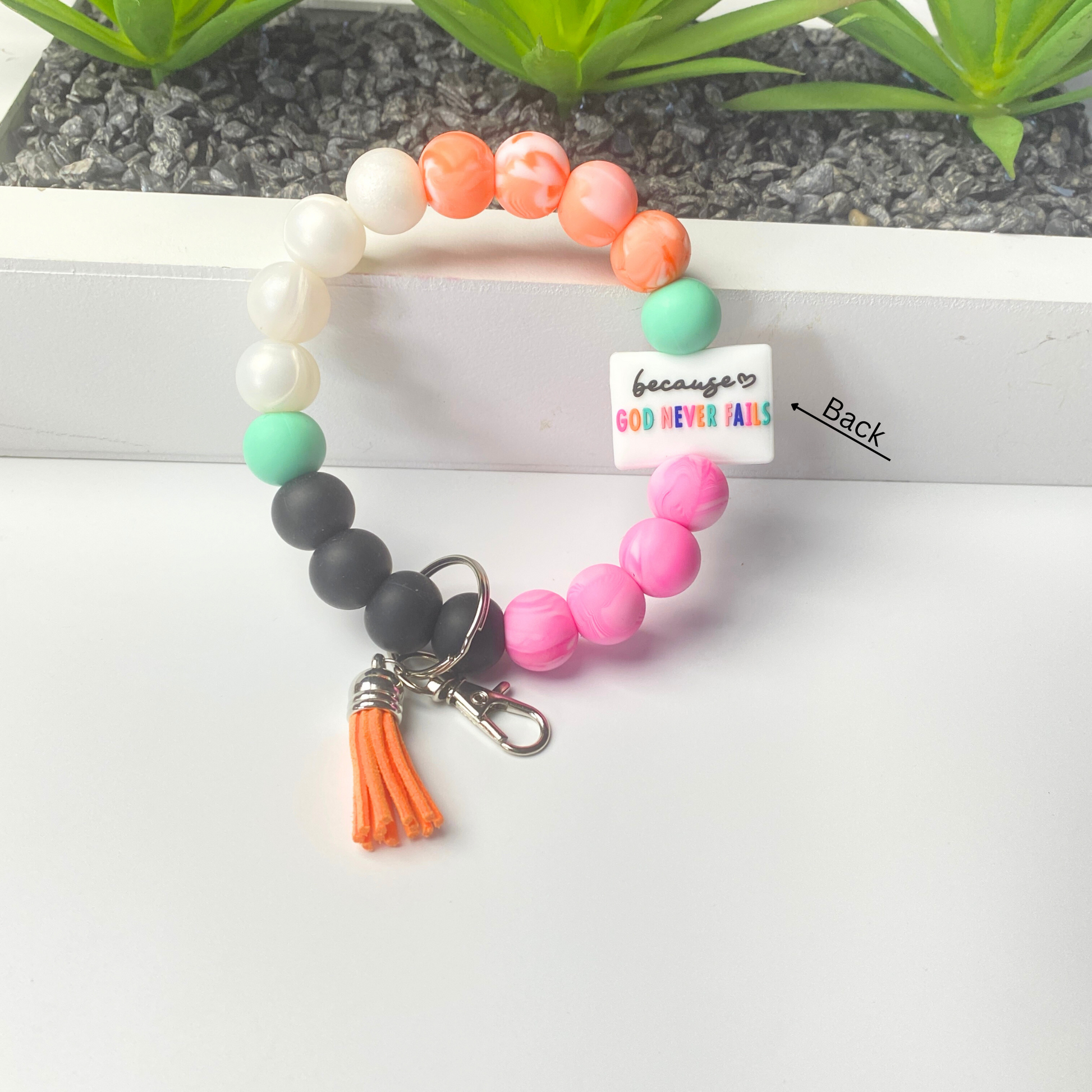 Colorful beaded keychain with tassel on a white background