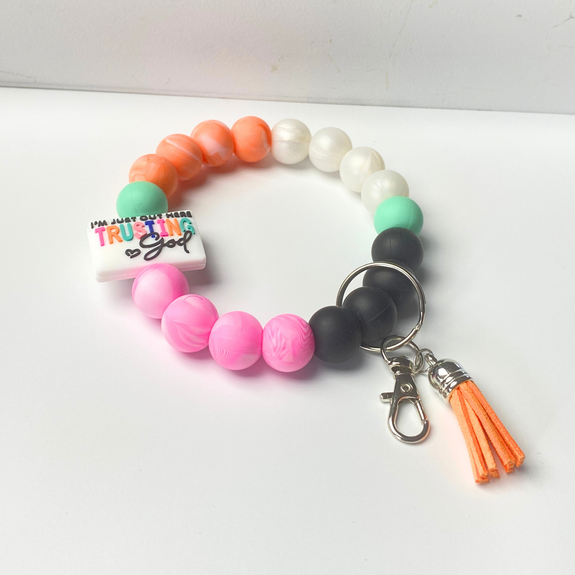 Colorful beaded bracelet with a keychain and tassel on a white background