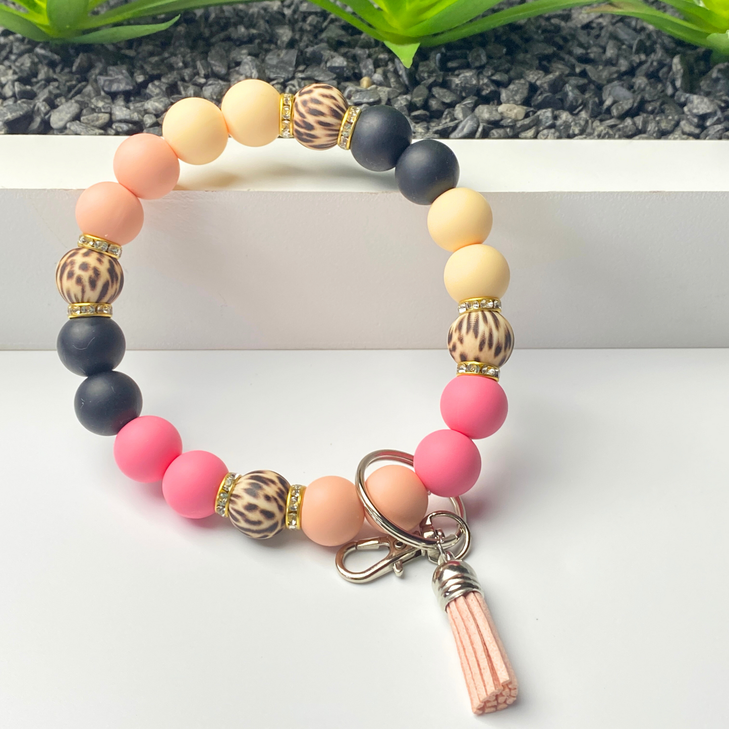 Beaded bracelet with keychain attachment on a white surface