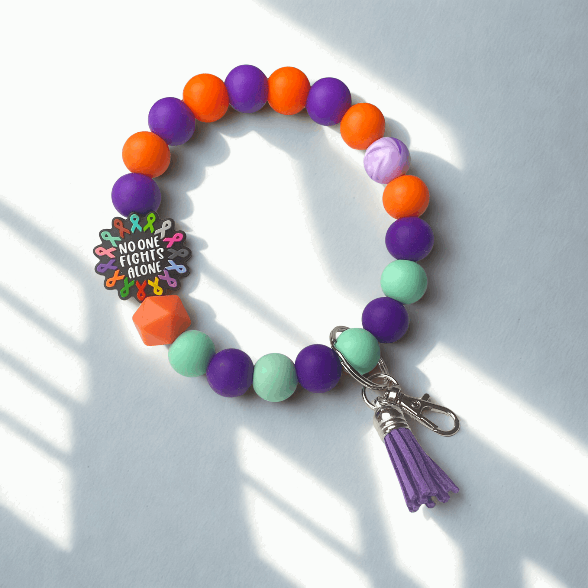 Colorful beaded bracelet with a keychain on a light background