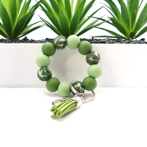 Green beaded bracelet with a tassel keychain on a white background