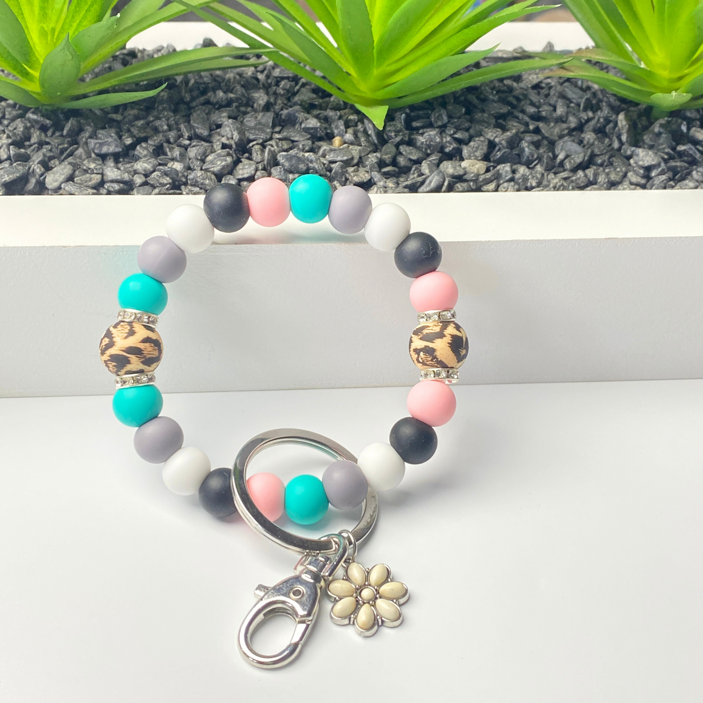 Colorful beaded keychain with a flower charm on a white surface.