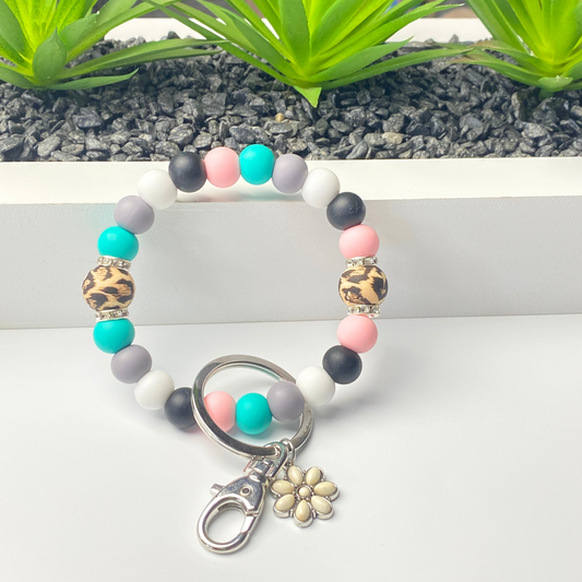 Colorful beaded keychain with a flower charm on a white surface.