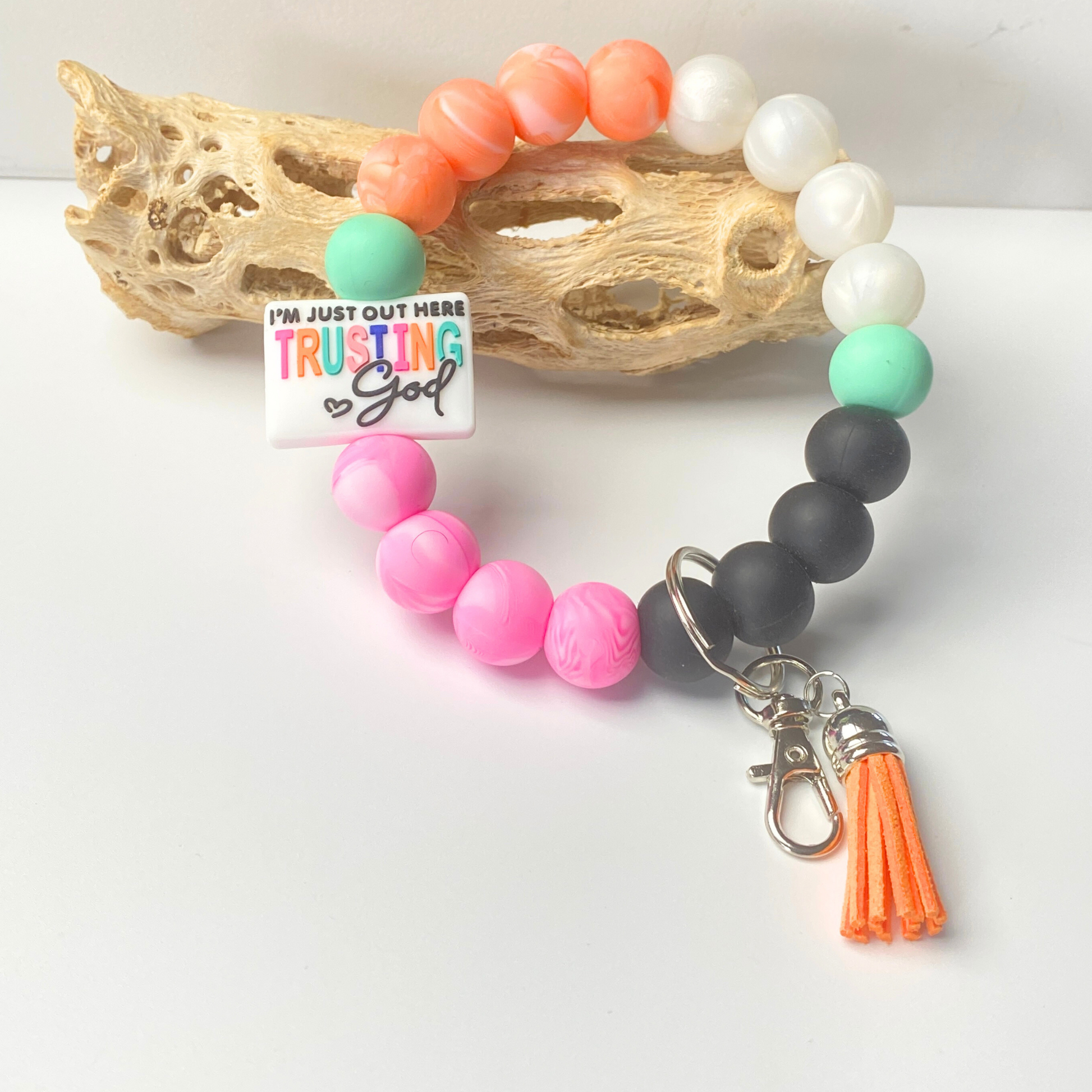 Colorful beaded bracelet with a tassel charm on a white background