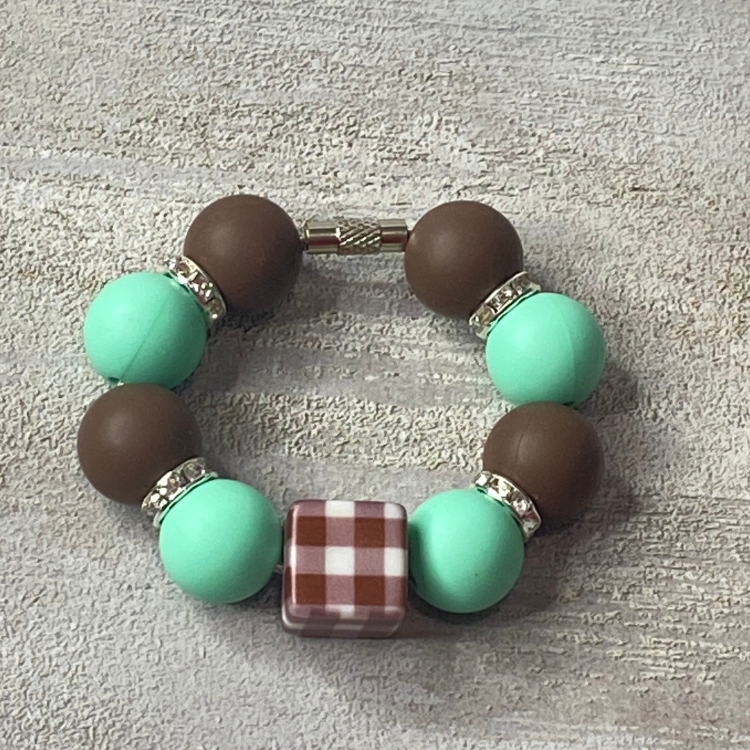 Bracelet with turquoise and brown beads on a textured surface
