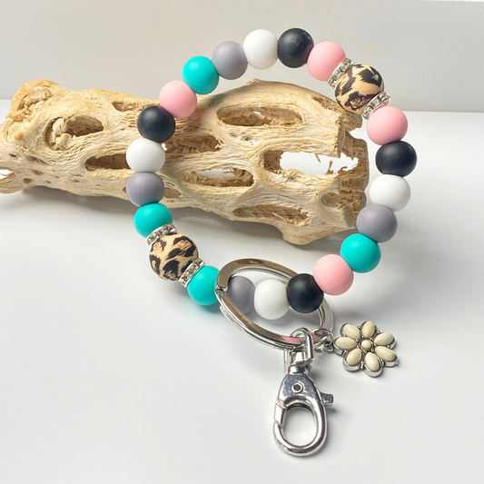 Beaded keychain with colorful beads and a flower charm on a white background