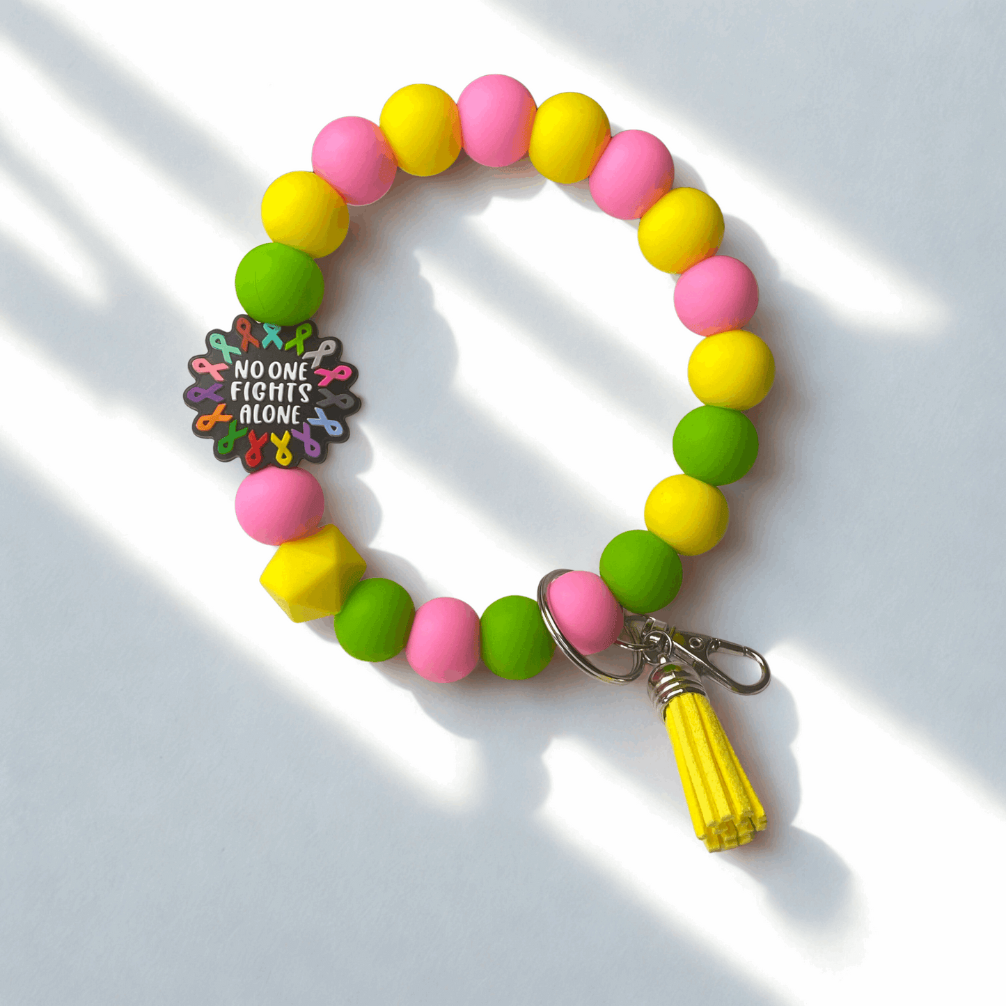 Colorful beaded bracelet with a tassel on a light background