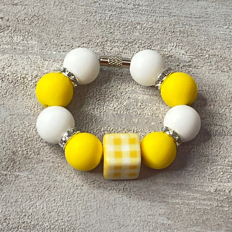 Bracelet with yellow and white beads on a textured surface